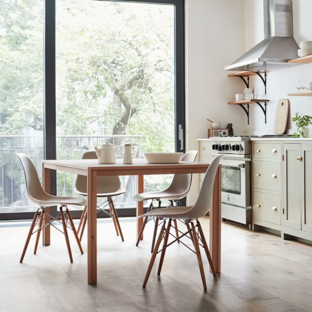The white shell Eames Molded Plastic Side Chair Dowel-Leg Base from Herman Miller in a living room.