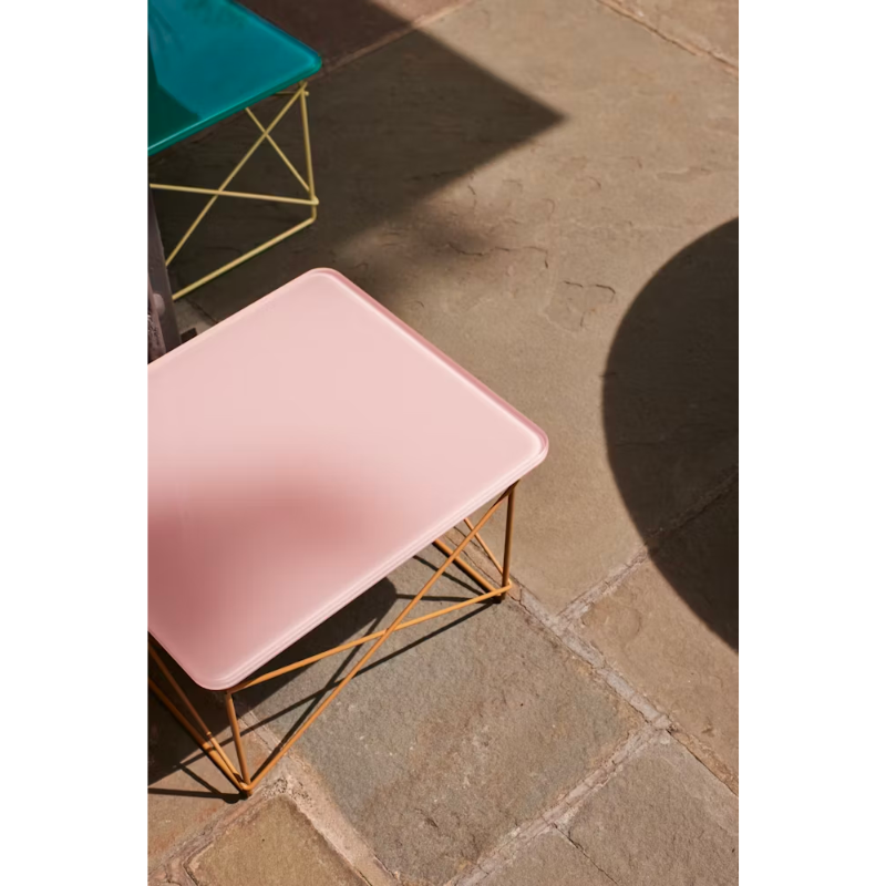 The powder pink and toffee Eames Wire Base Low Table, Herman Miller x HAY from Herman Miller outdoors.