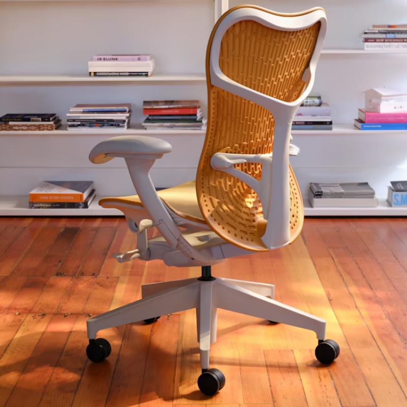 The Mirra 2 Chair from Herman Miller with the butterfly suspension back and alpine frame in ochre color in a family room.