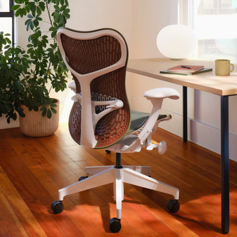 The Mirra 2 Chair from Herman Miller with the butterfly suspension back and alpine frame in olive color within a home office.