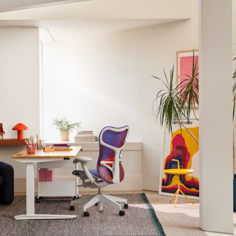 The Mirra 2 Chair from Herman Miller with the butterfly suspension back and alpine frame in ultramarine blue color in an art studio.