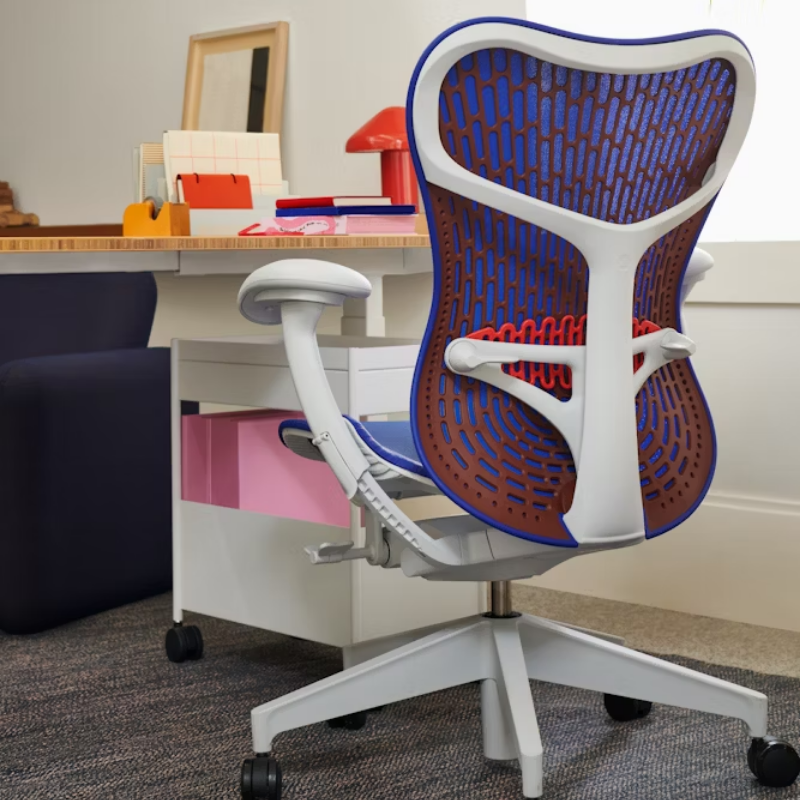 The Mirra 2 Chair from Herman Miller with the butterfly suspension back and alpine frame in ultramarine blue color in a study area.