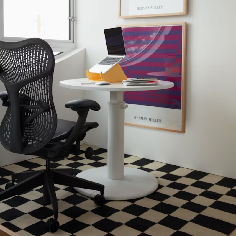 The Mirra 2 Chair from Herman Miller with the butterfly suspension back and graphite frame in alpine color in a living room.