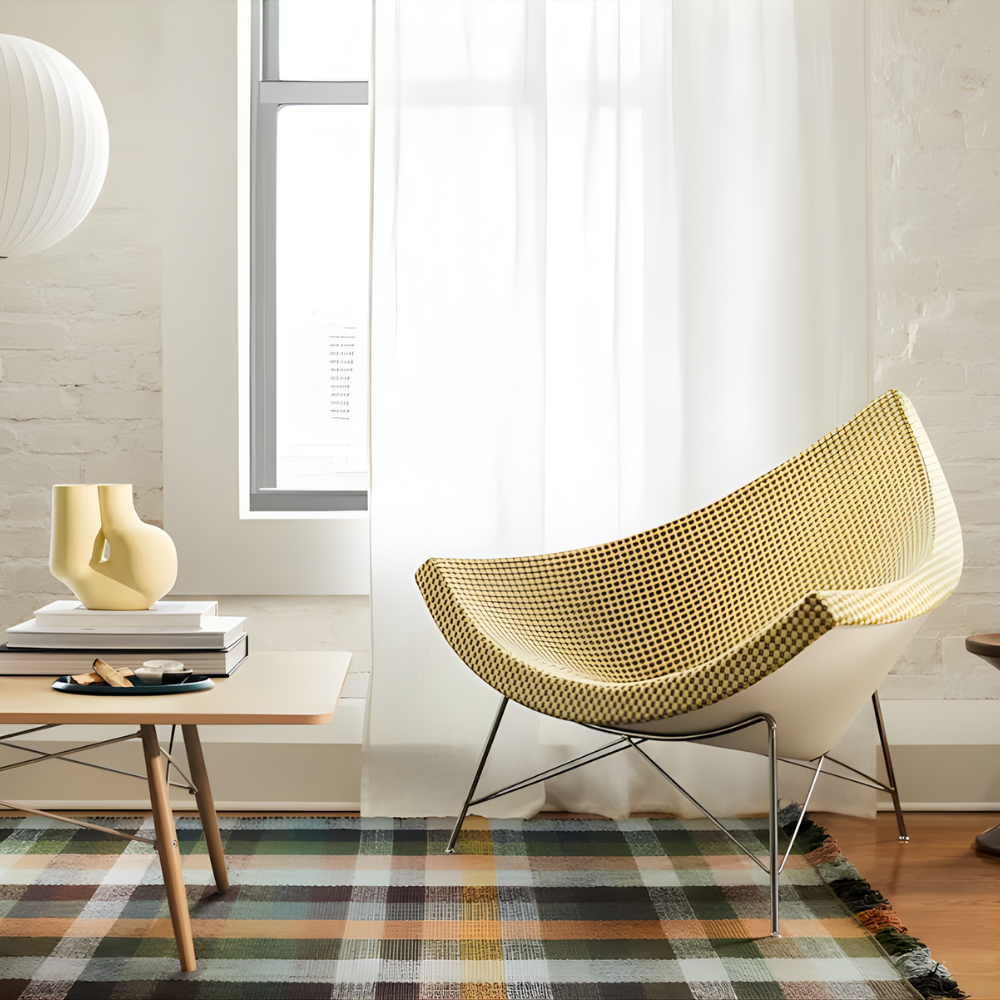 The Nelson Coconut Chair from Herman Miller with the light emerald and ivory checker upholstery and chrome base in a family area.