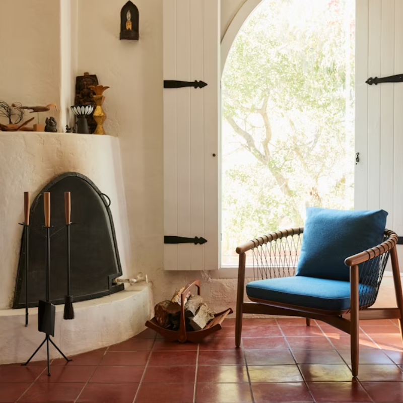 The Nelson Fireplace Tool Set from Herman Miller in a living room.