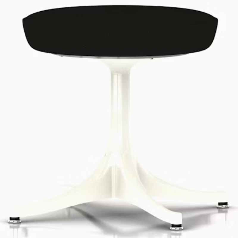 The Nelson Pedestal Stool from Herman Miller with black hopsak upholstery and a white base.