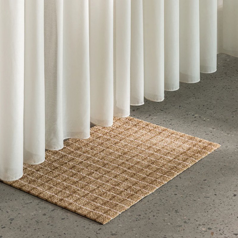 The Grid Doormat from Heymat in chocolate strawberry in a lounge.