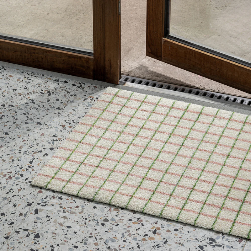 The Grid Doormat from Heymat in lime candycane in an entrway.