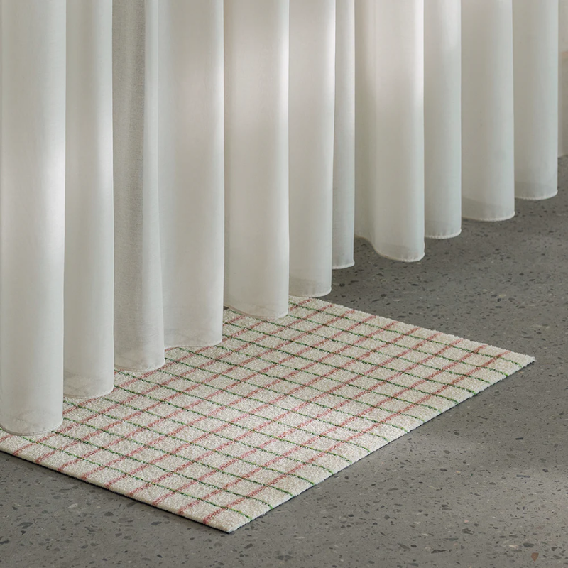The Grid Doormat from Heymat in lime candycane in a living room.