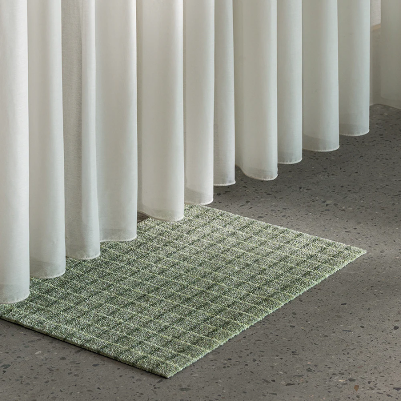 The Grid Doormat from Heymat in matcha lemon in a living room.