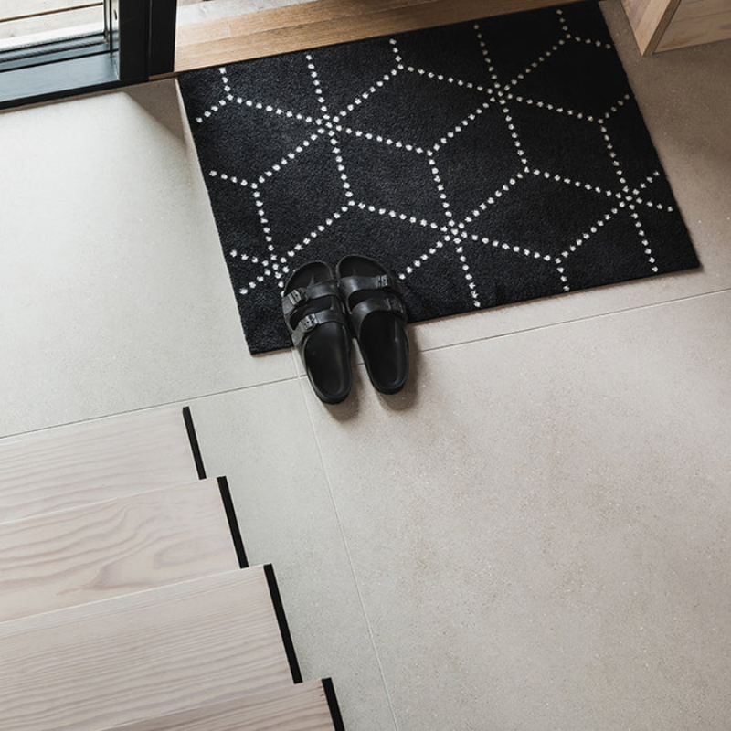The Hagl Doormat from Heymat in black in a living space.