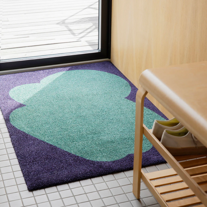 The Heymat x Sight Doormat from Heymat in unseen emerald in a living room.