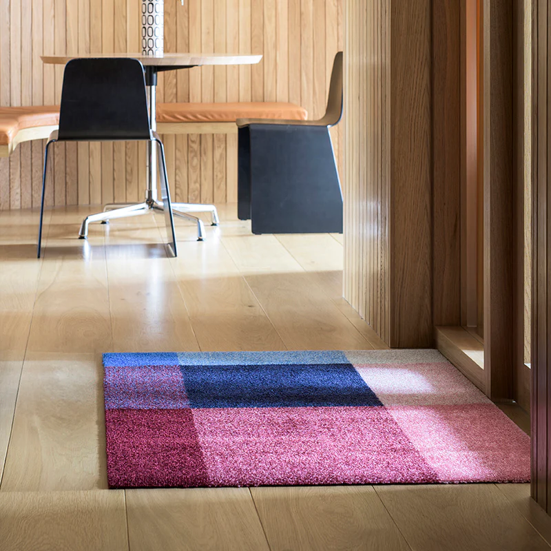 The Mix Doormat from Heymat in berry in a living room.