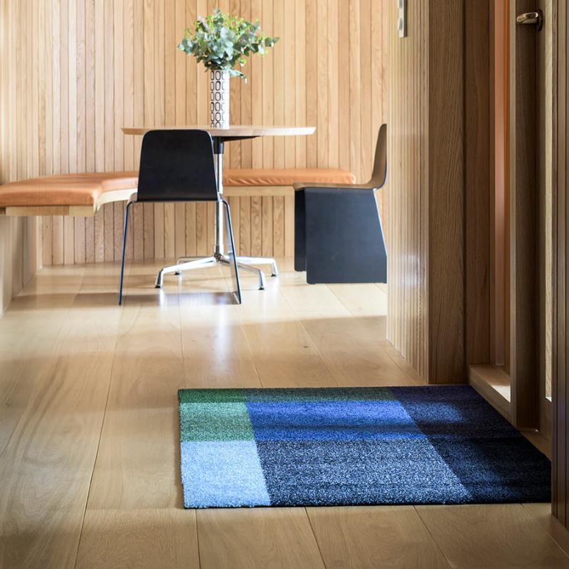 The Mix Doormat from Heymat in meadow in a dining room.