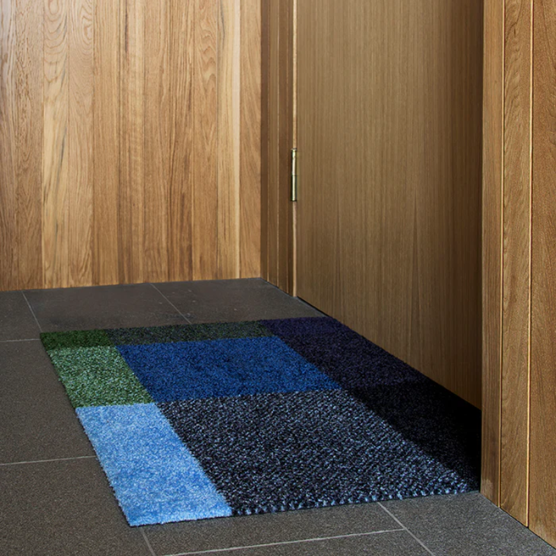 The Mix Doormat from Heymat in meadow in an entryway.