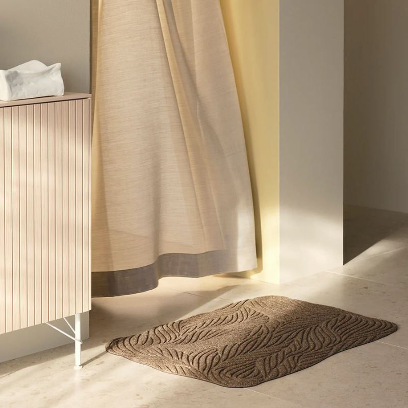 The Twine Doormat from Heymat in beige in a bedroom.