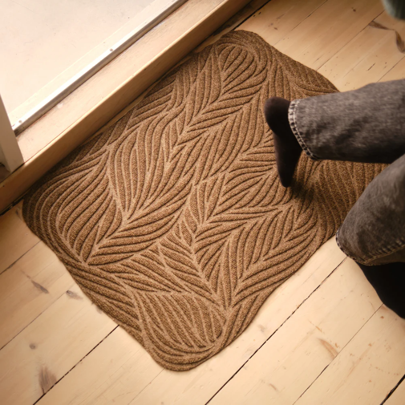 The Twine Doormat from Heymat in beige in a doorway.