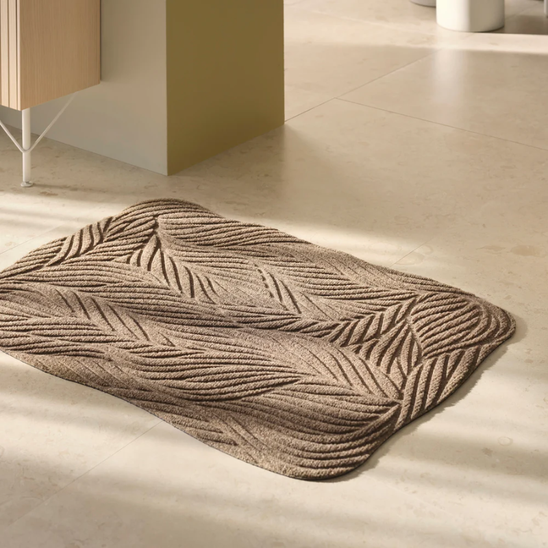 The Twine Doormat from Heymat in beige in a living room.