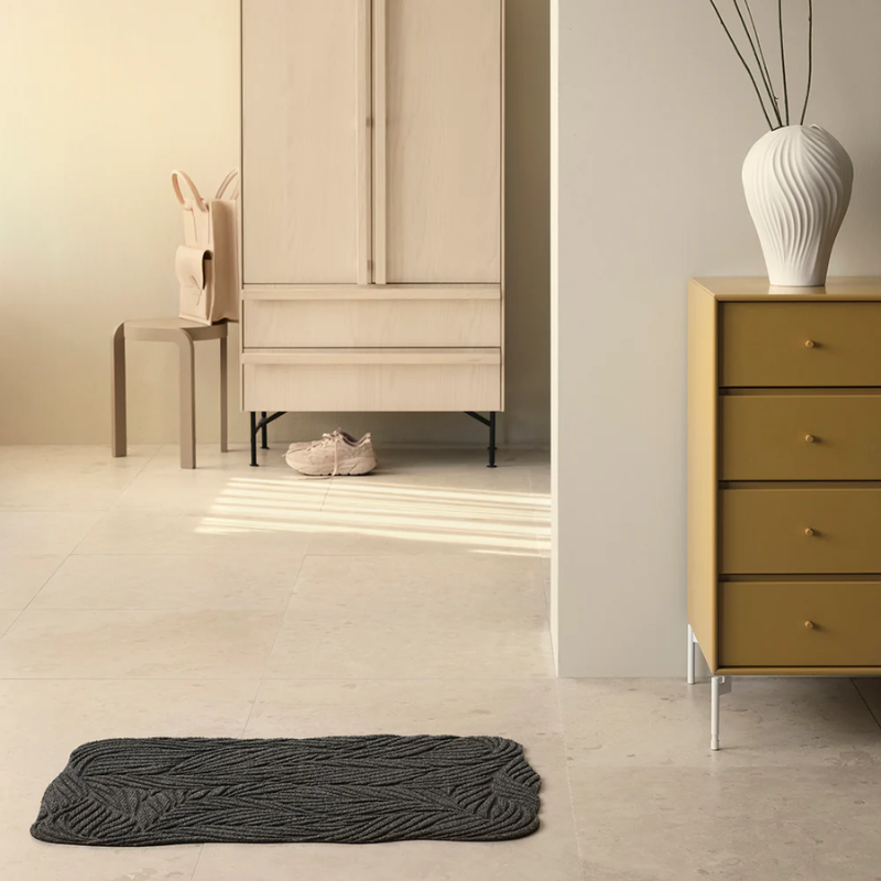 The Twine Doormat from Heymat in grey in a living room.