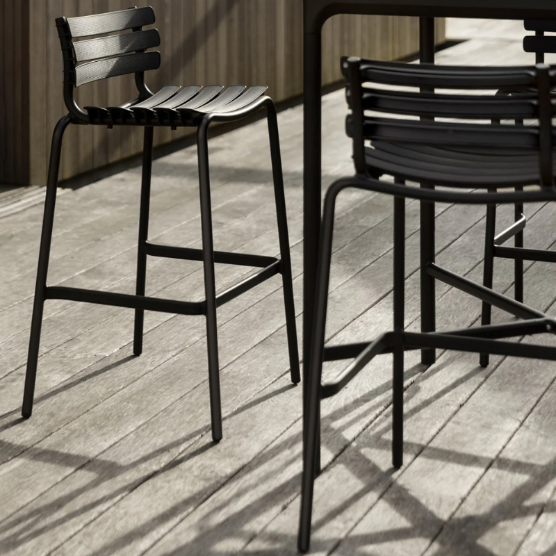 The ReClips Outdoor Bar Chair by Houe with detailing on a wooden deck.