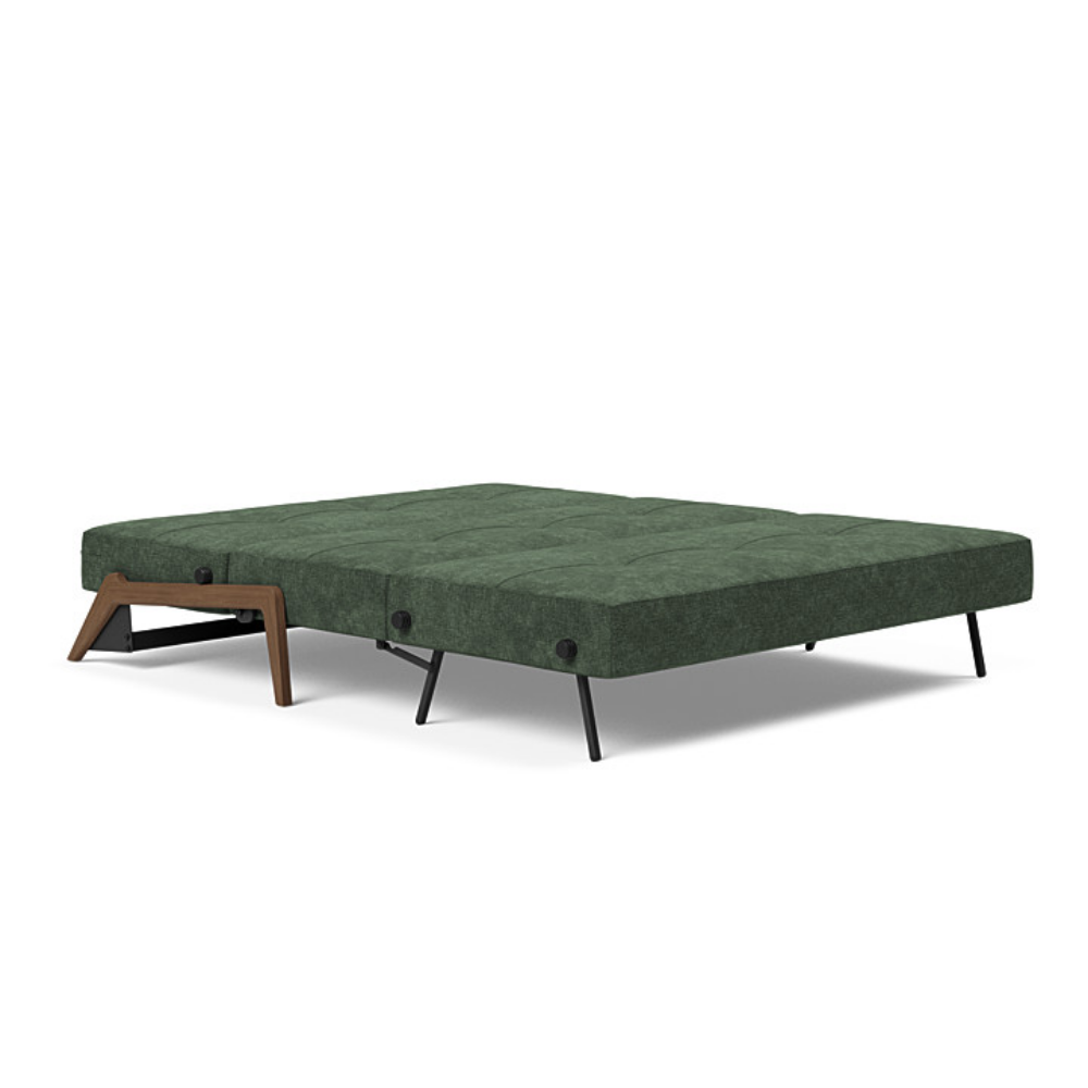 The Cubed Queen Size Sleeper Sofa with Wood Legs from Innovation Living with dark lacquered oak legs and avella pine green 281 upholstery setup as a bed.