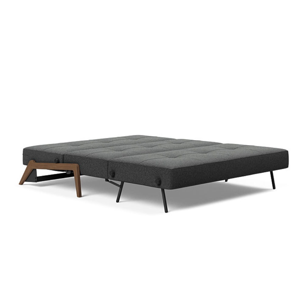 The Cubed Queen Size Sleeper Sofa with Wood Legs from Innovation Living with dark lacquered oak legs and boucle charcoal 529 upholstery setup as a bed.