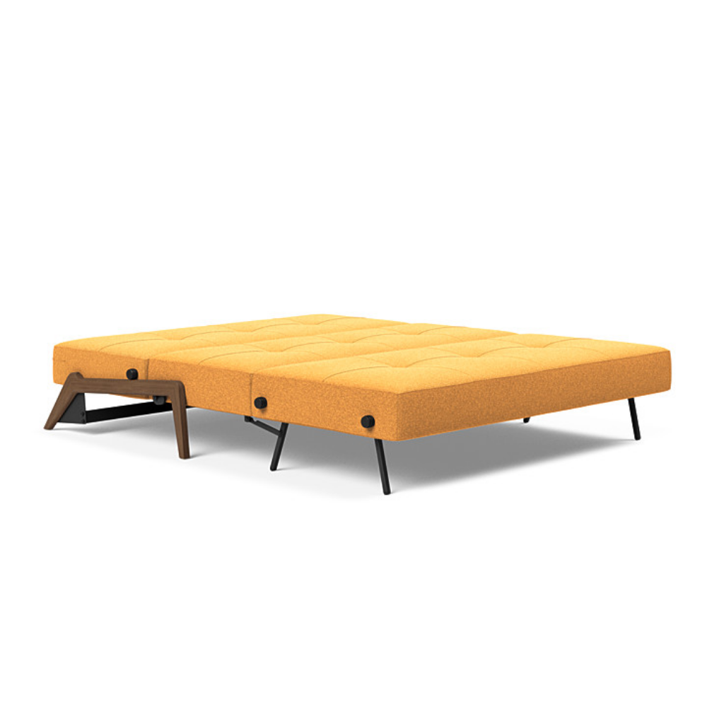 The Cubed Queen Size Sleeper Sofa with Wood Legs from Innovation Living with dark lacquered oak legs and boucle ochre 536 upholstery setup as a bed.