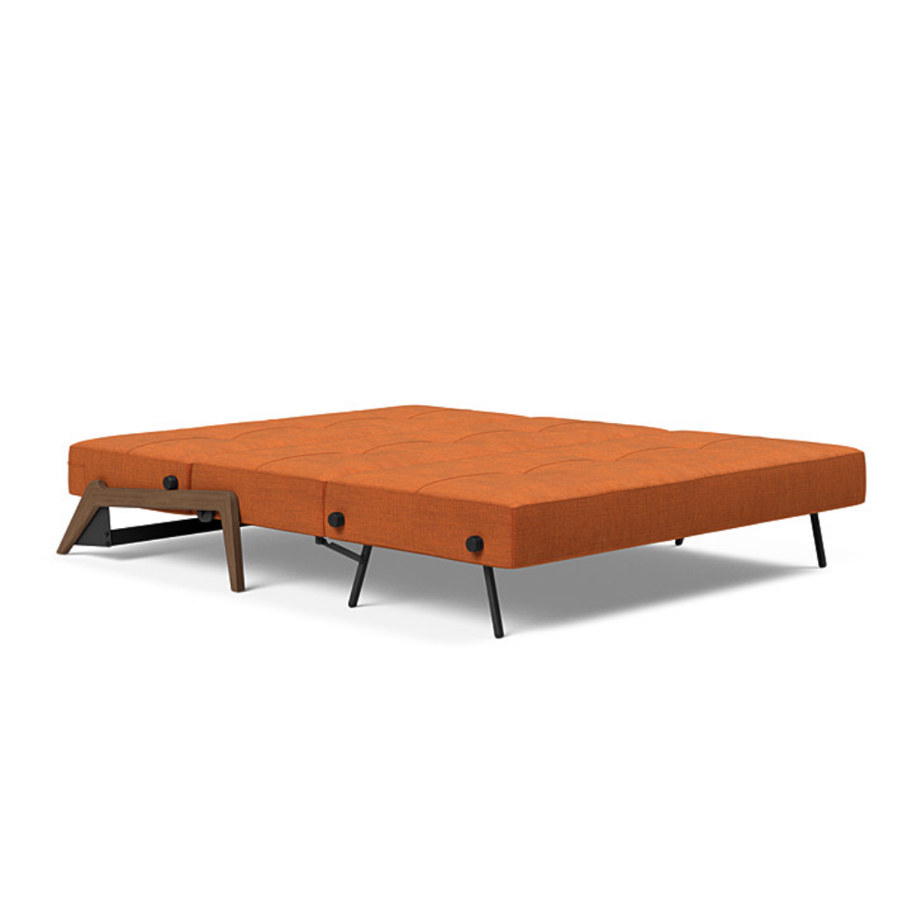 The Cubed Queen Size Sleeper Sofa with Wood Legs from Innovation Living with dark lacquered oak legs and esina rust orange 412 upholstery setup as a bed.