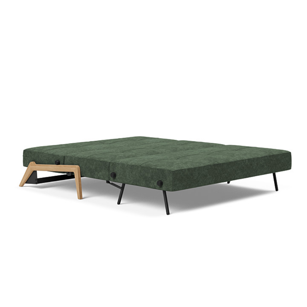 The Cubed Queen Size Sleeper Sofa with Wood Legs from Innovation Living with lacquered oak legs and avella pine green 281 upholstery setup as a bed.