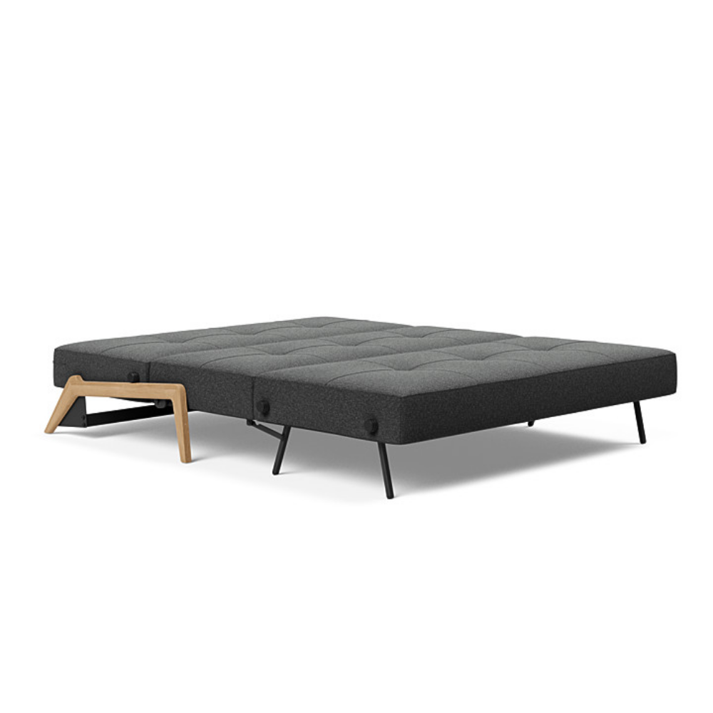 The Cubed Queen Size Sleeper Sofa with Wood Legs from Innovation Living with lacquered oak legs and boucle charcoal 529 upholstery setup as a bed.