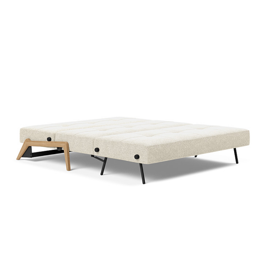The Cubed Queen Size Sleeper Sofa with Wood Legs from Innovation Living with lacquered oak legs and taura off white 357 upholstery setup as a bed.