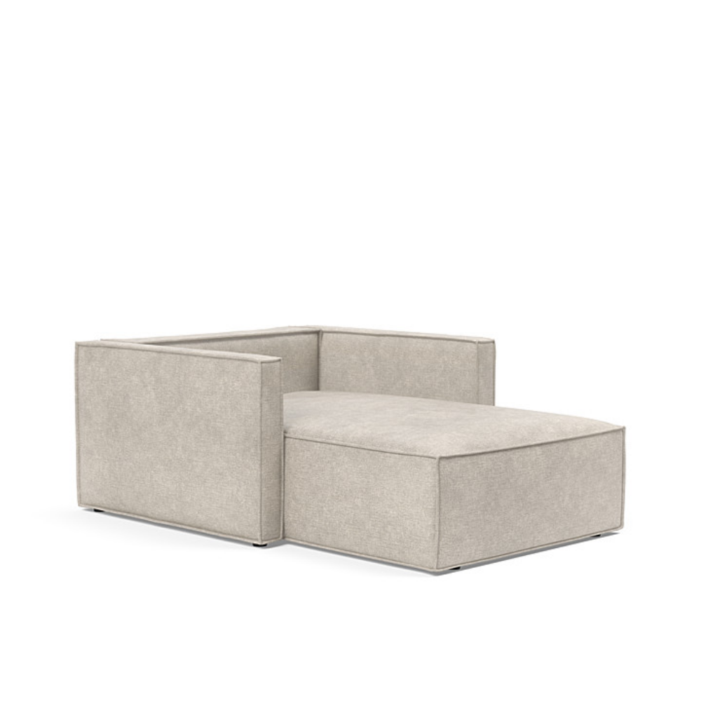 The Newilla Lounger Chair with Slim Arms with avella sand 280 upholstery without the cushion, setup as a bed.