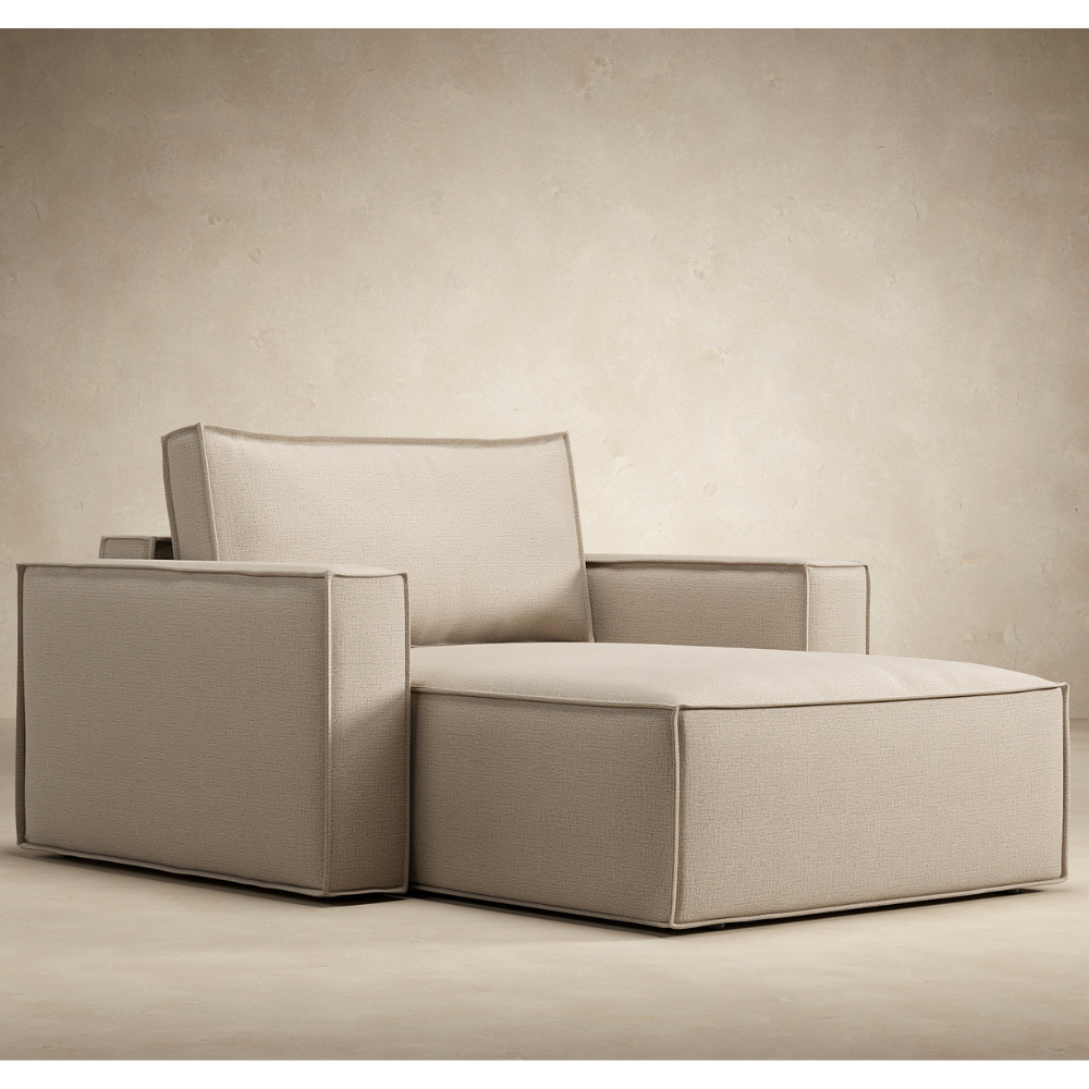 The Newilla Lounger Chair with Standard Arms from Innovation Living with adario taupe 257 upholstery from an angle in a living space. all-groups