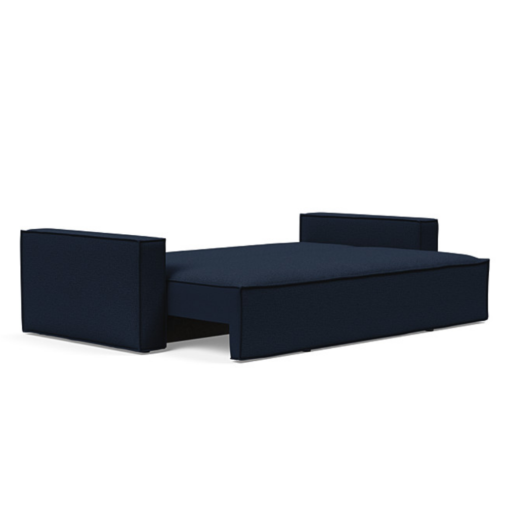 The Newilla Sleeper Sofa from Innovation Living with wide arms and mixed dance blue 528 upholstery setup as a bed.
