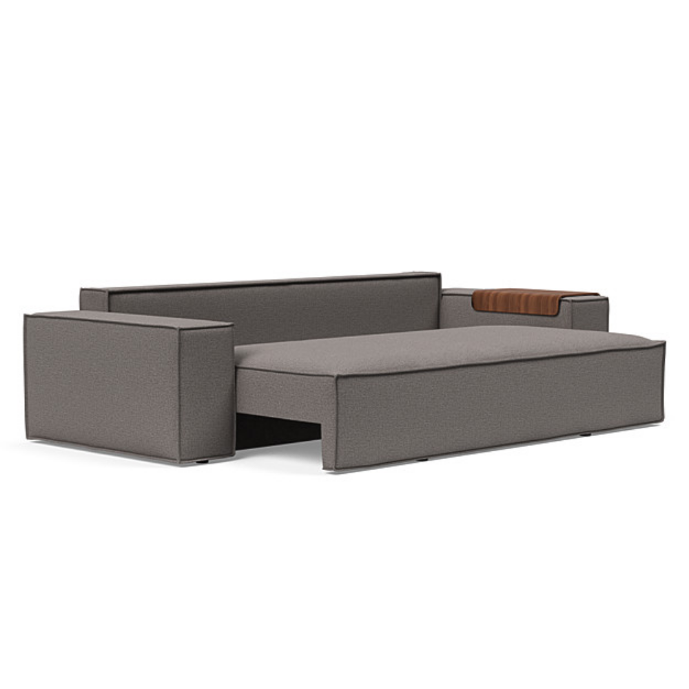 The Newilla Sleeper Sofa from Innovation Living with wide arms and mixed dance grey 521 upholstery seat pulled out of the couch.