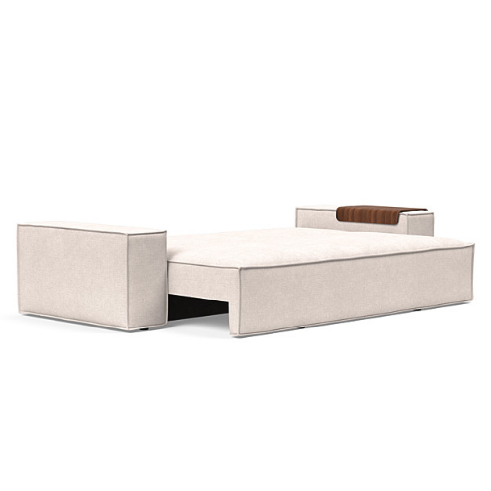 The Newilla Sleeper Sofa from Innovation Living with wide arms and adario basmati 255 upholstery setup as a bed.