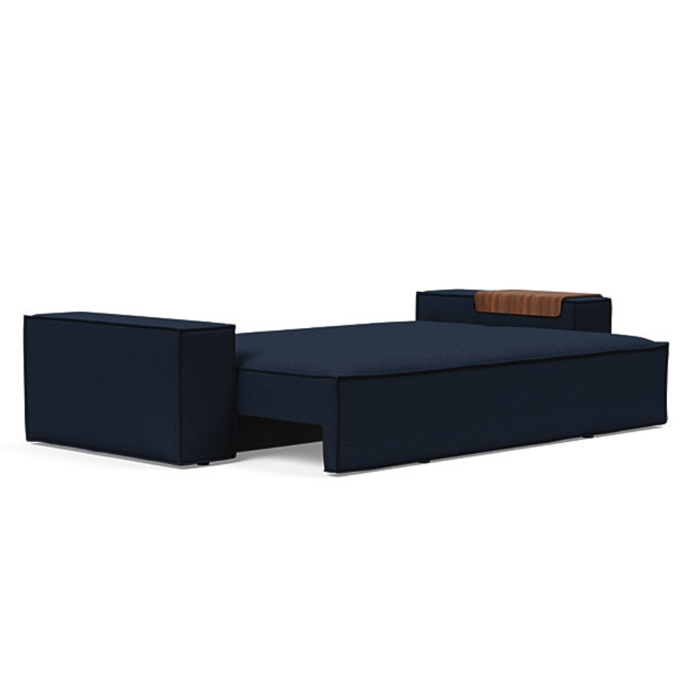 The Newilla Sleeper Sofa from Innovation Living with wide arms and mixed dance blue 528 upholstery setup as a bed.
