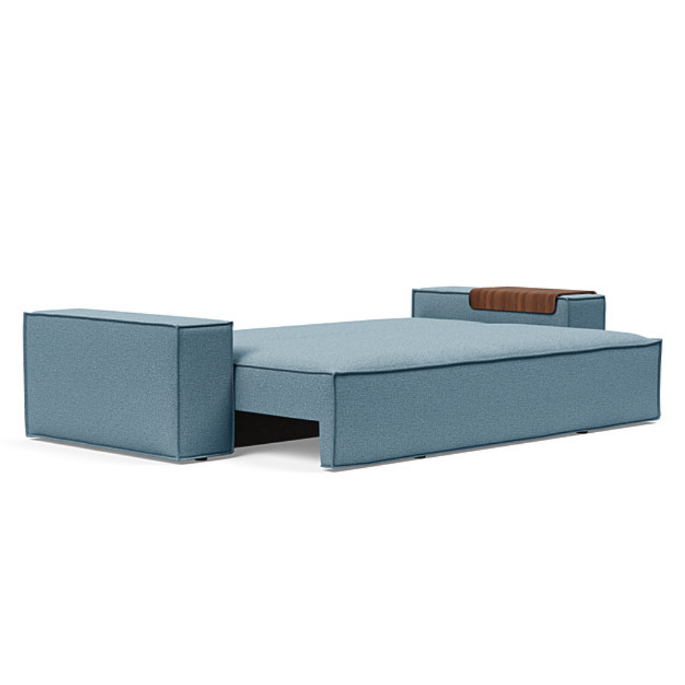 The Newilla Sleeper Sofa from Innovation Living with wide arms and mixed dance light blue 525 upholstery setup as a bed.