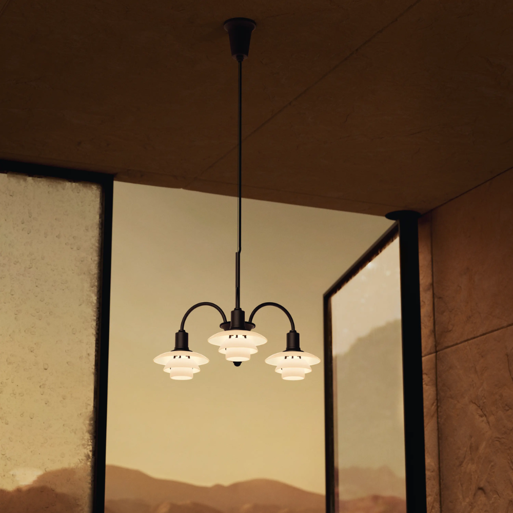 Campaign photo of the PH 1/1 Chandelier, 3-Light by Louis Poulsen turned on.