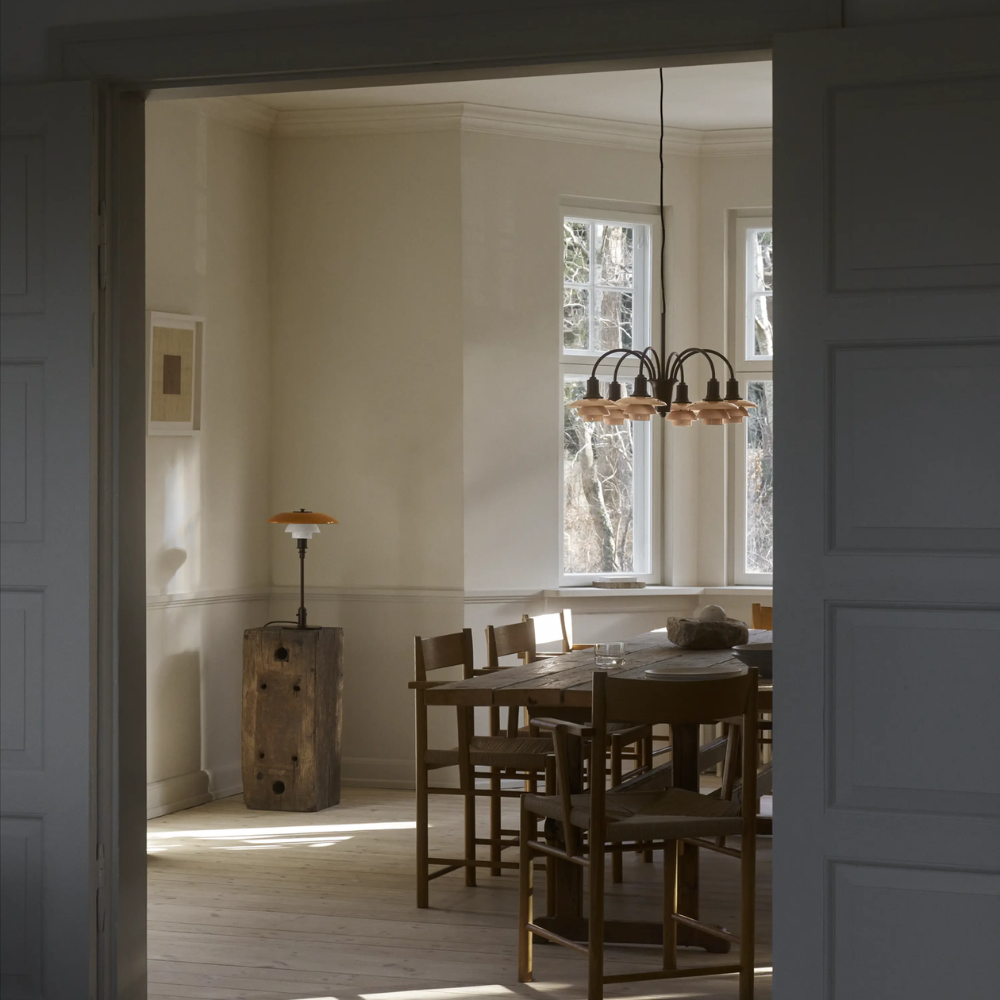 The PH 1/1 Chandelier, 6-Light by Louis Poulsen in a dining room turned off.