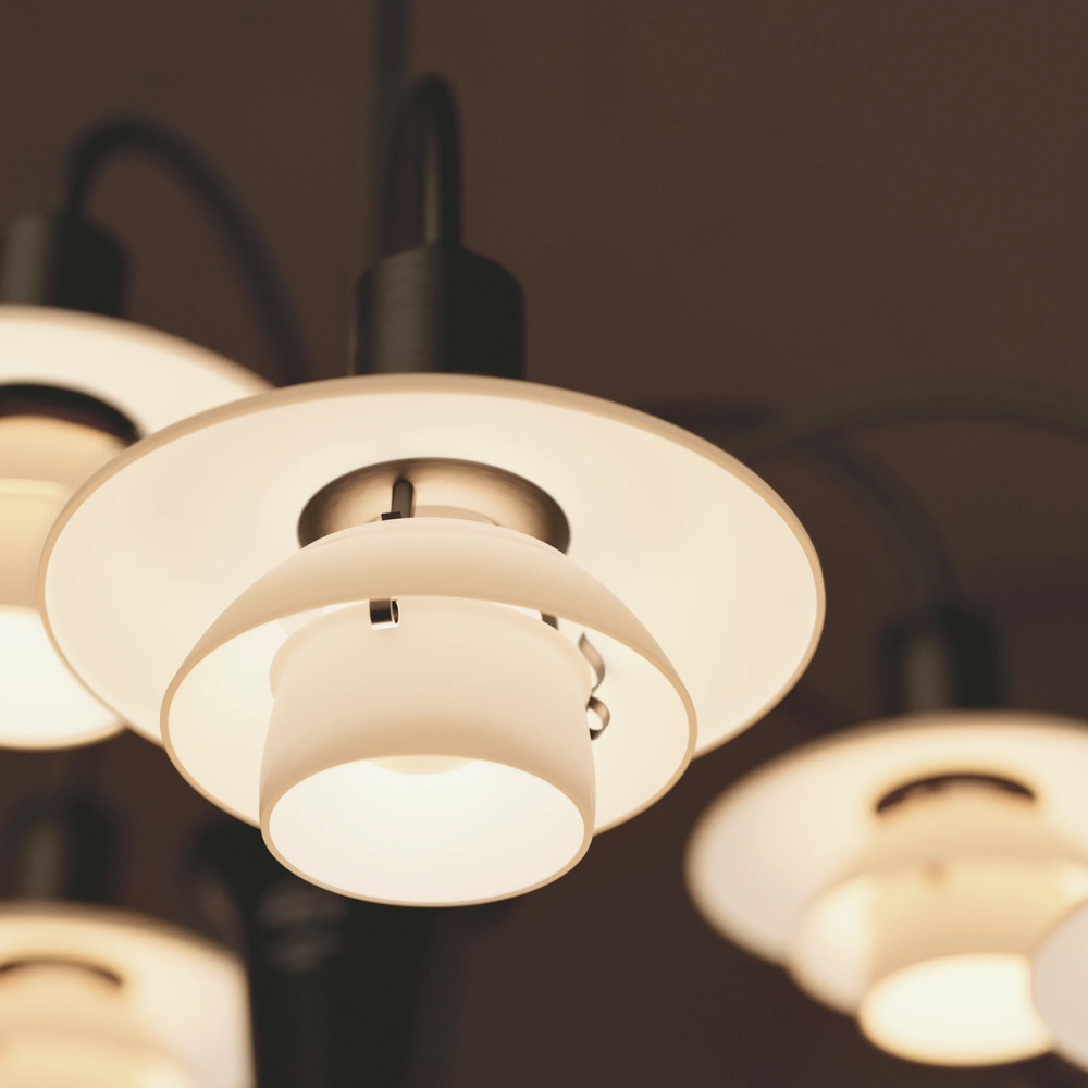 Detailed image of the shade of PH 1/1 Chandelier, 9-Light by Louis Poulsen turned on.