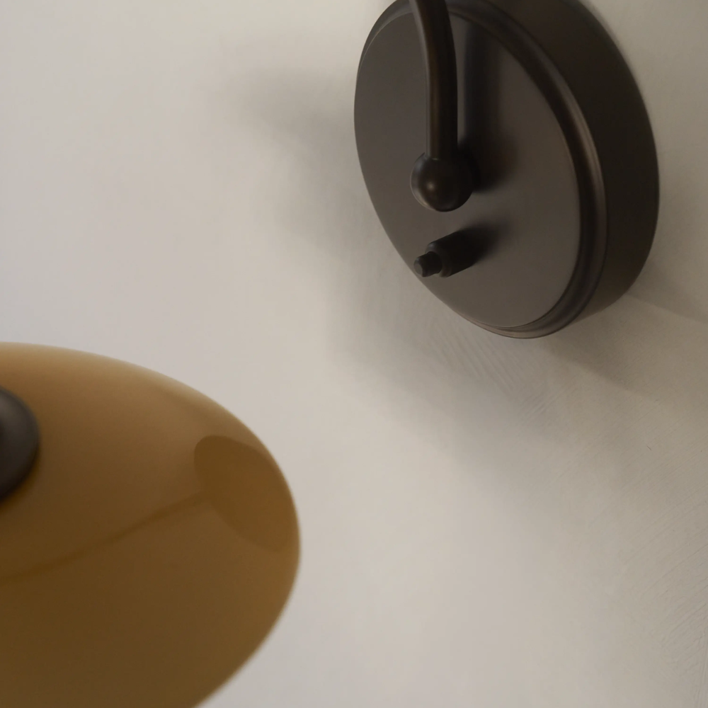 Detailed image of the lacquered base of the PH 2/2 Wall Lamp Centenary Edition while turned off.