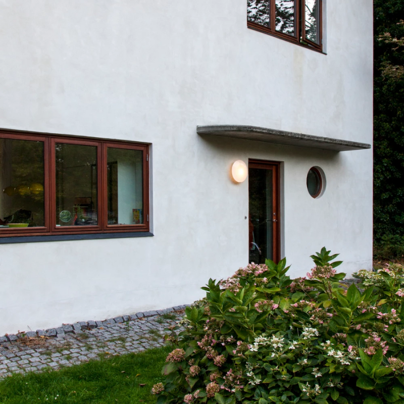 The AJ Eklipta Outdoor from Louis Poulsen next to a doorway. all-groups