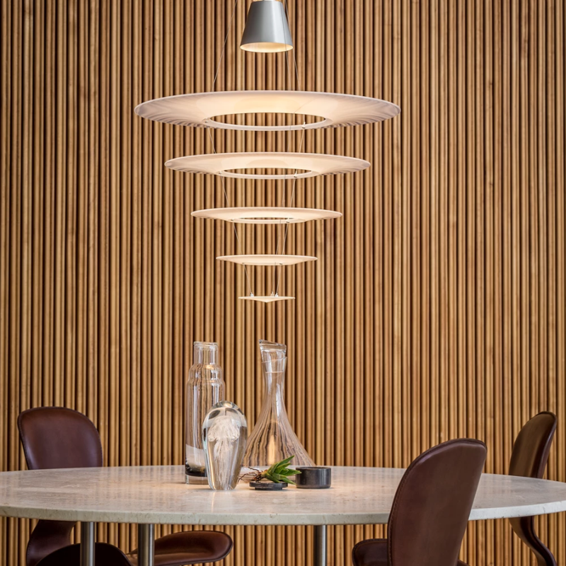 The Enigma 545 from Louis Poulsen in brushed aluminum in a dining room.