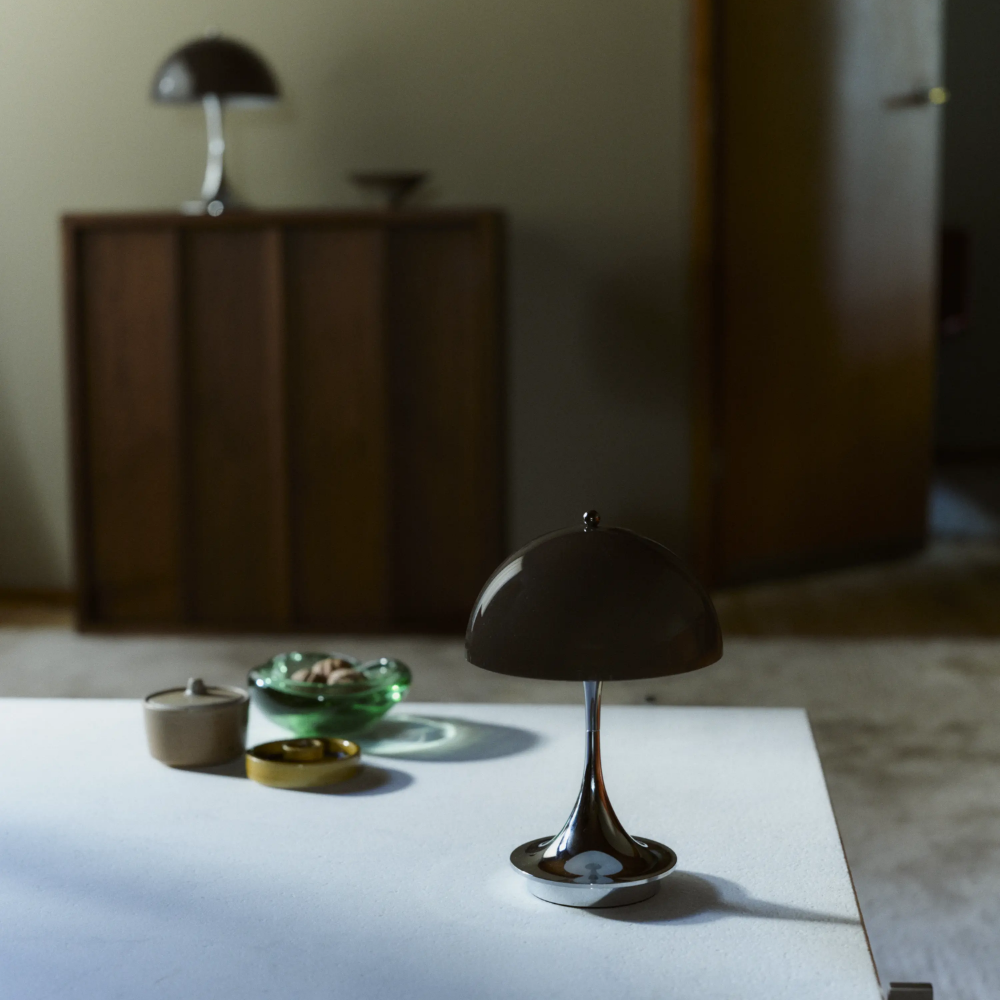 The Panthella 160 Portable Lamp from Louis Poulsen in Original Opal Brown on a table turned off.