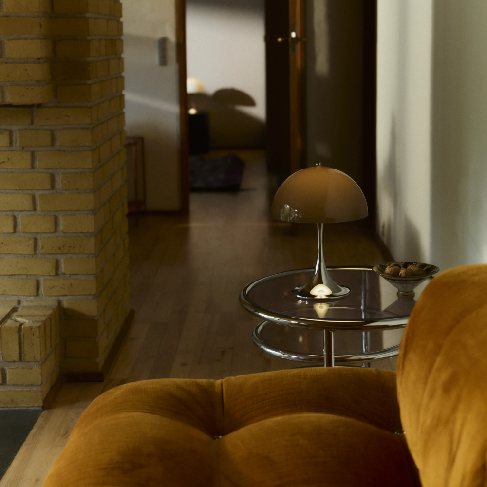The Panthella 250 Portable Table Lamp from Louis Poulsen in Original Opal Brown in a living room.