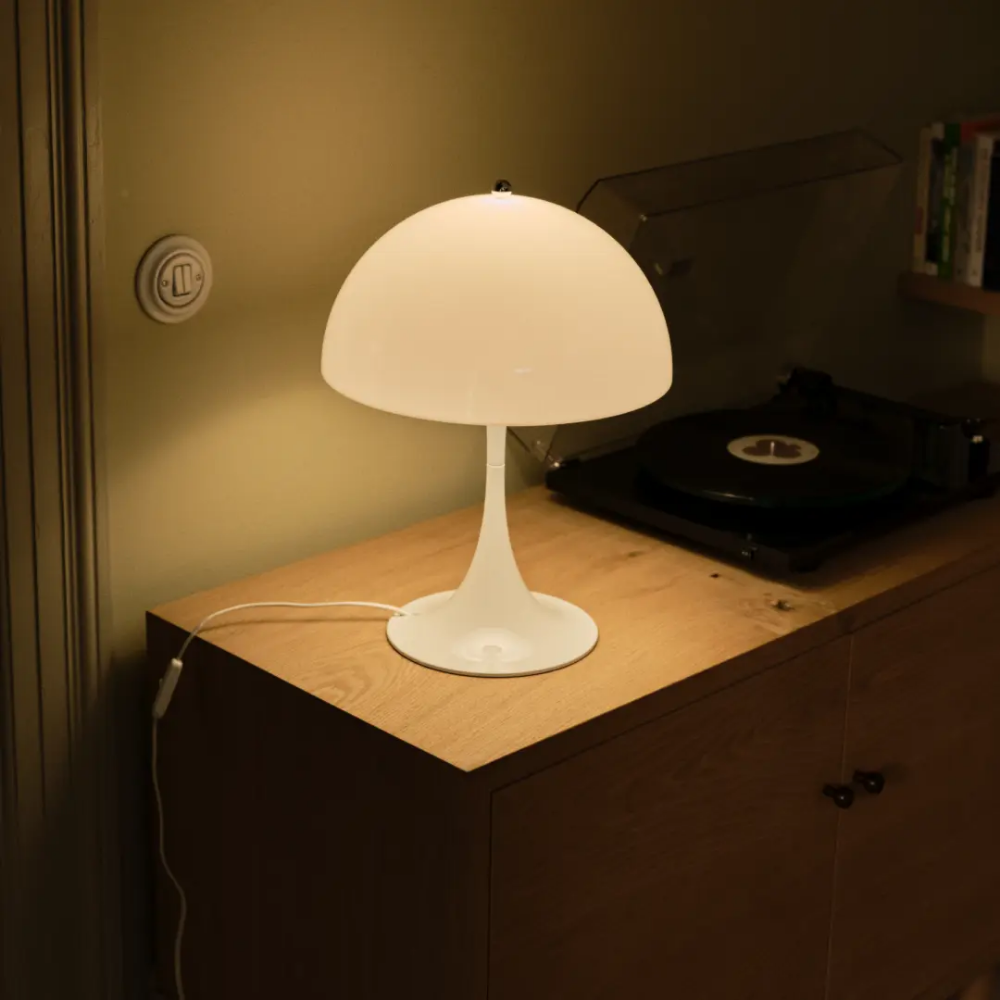The Panthella 320 Table Lamp from Louis Poulsen in opal white in a living room.
