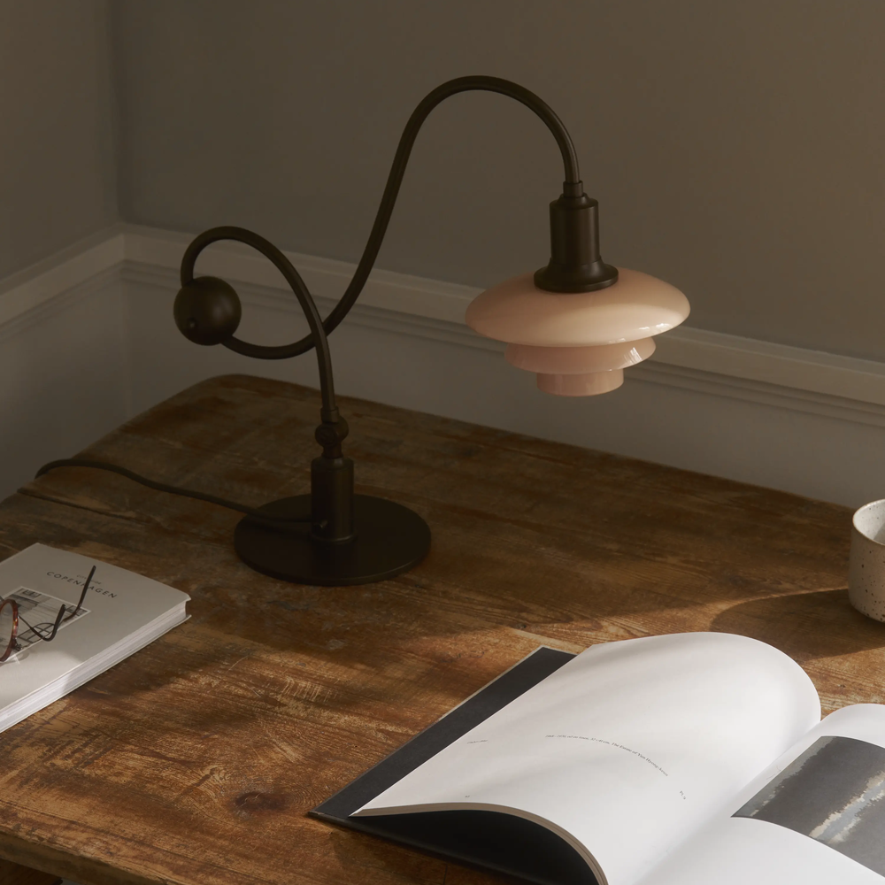 The PH 1/1 Piano Table Lamp by Louis Poulsen on a desk.