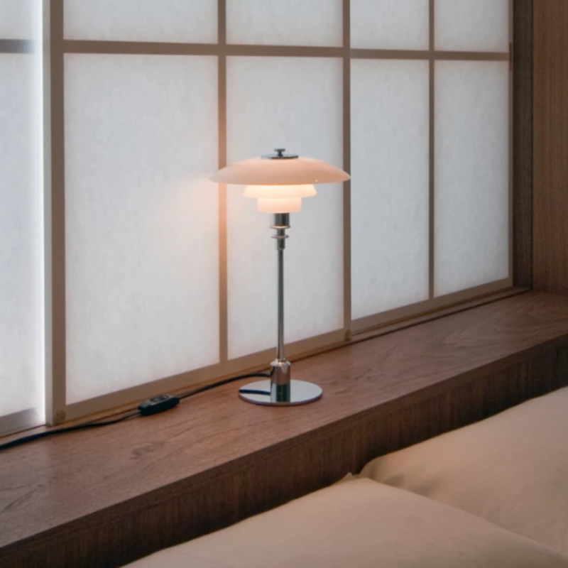 The chrome PH 2/1 Table Lamp from Louis Poulsen in a home office.