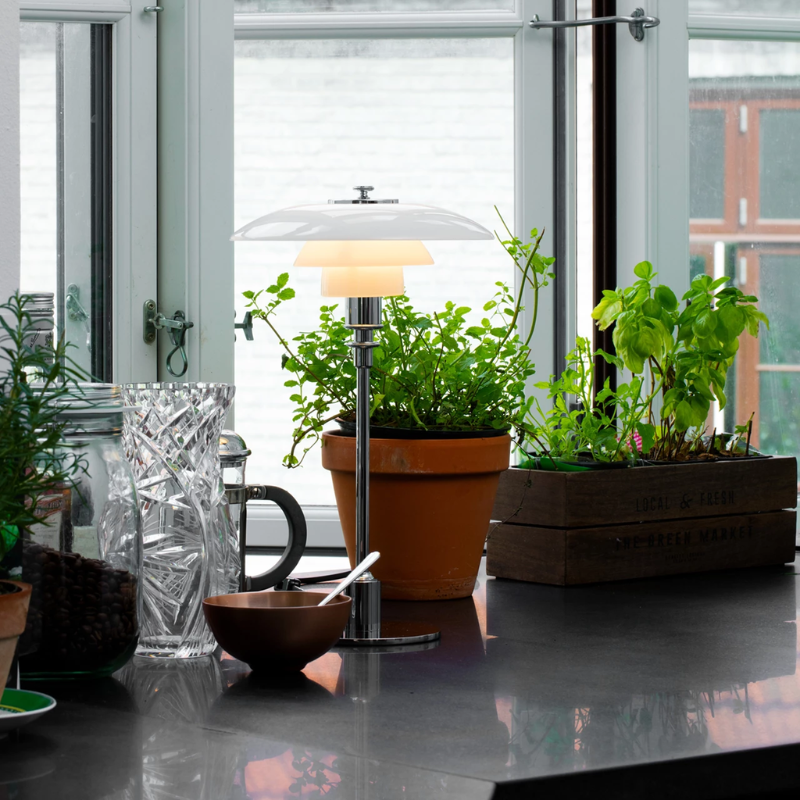 The chrome PH 2/1 Table Lamp from Louis Poulsen in a kitchen and dining setting.